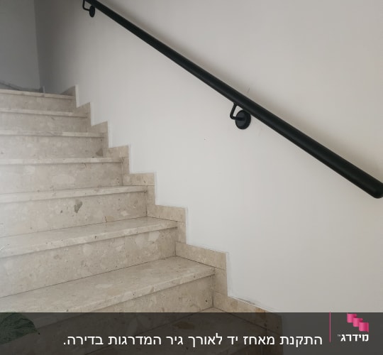 מעקה שחור על קיר ליד מדרגות אבן